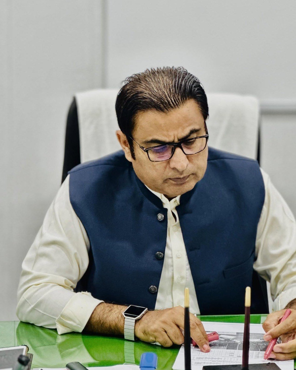 Dr. Khalid Hussain Mazari reviewing patient records at his desk